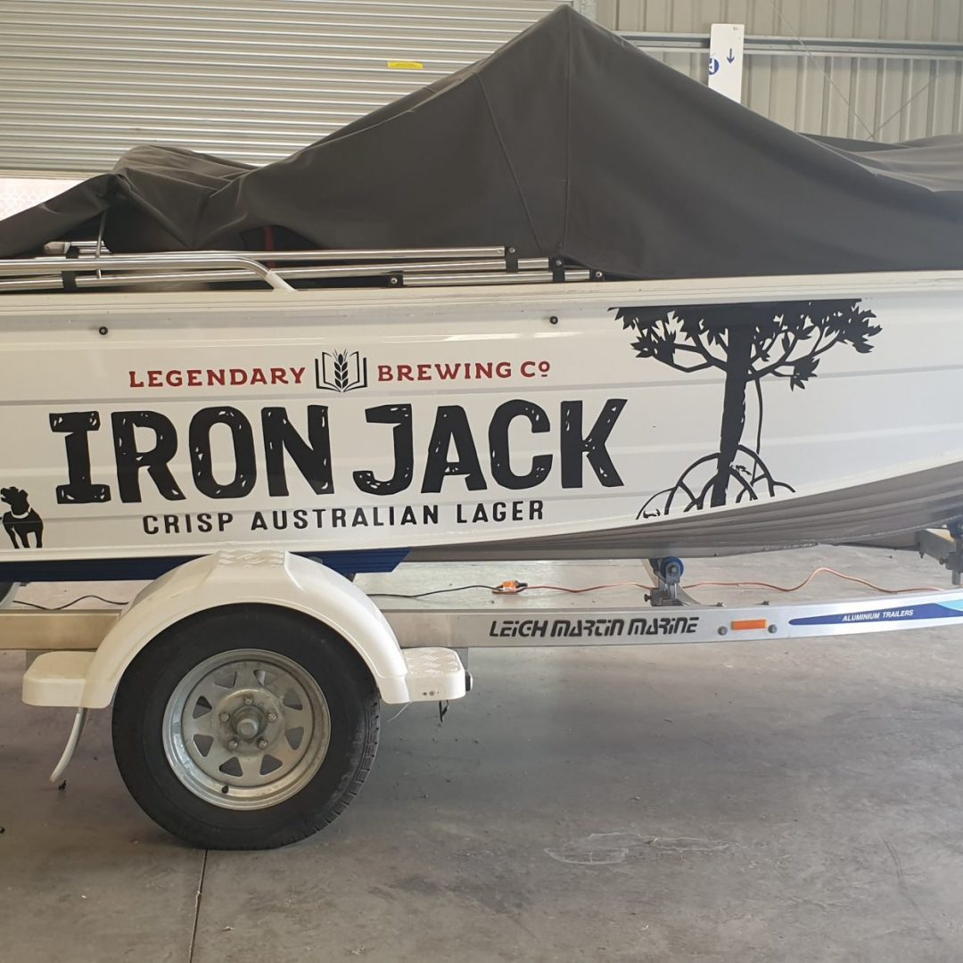 Boat with graphic print on side on a trailer in shed - vehicle wraps Albury-Wodonga