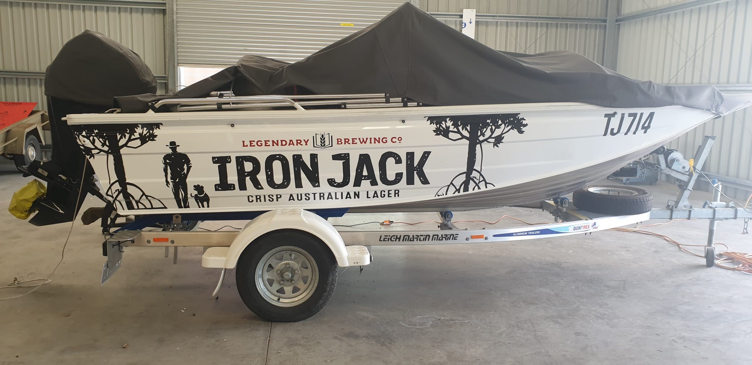 Boat with graphic print on side on a trailer in shed - vehicle wraps Albury-Wodonga